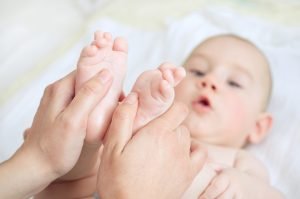 Mother gently massaging her childs feet