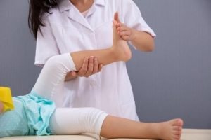 woman helping a child stretch their foot